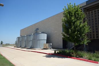 Rainwater retention tanks stand on the side of Kiowa County High School in Greensburg, Kansas.